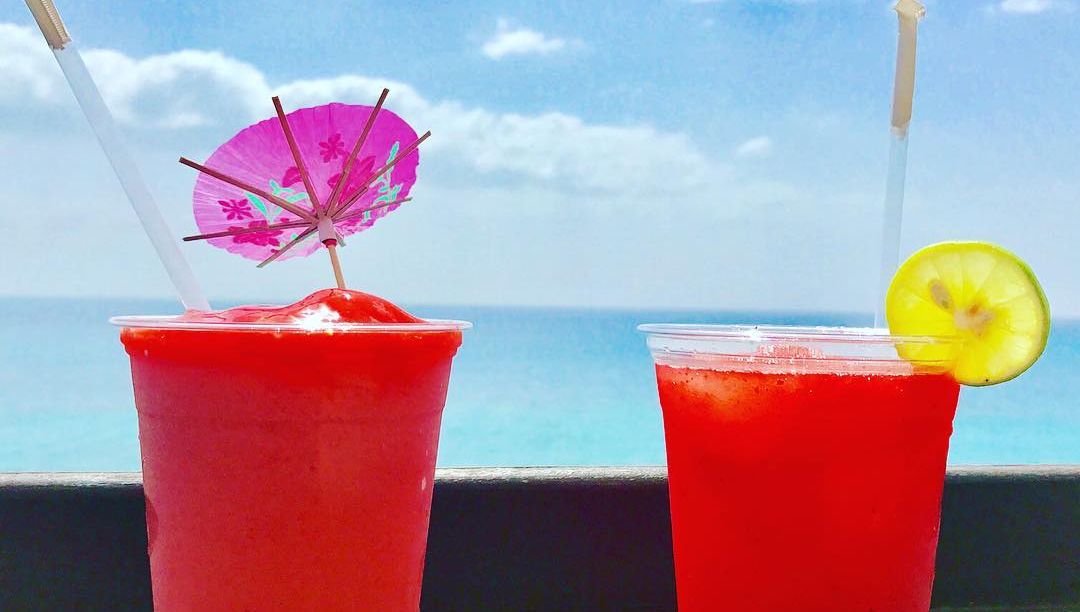 Red slushy cocktails by the ocean