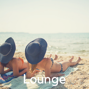 Two girls in black sunhats laying on the beach.