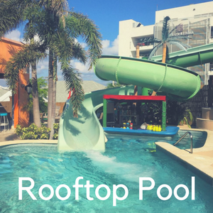 A slide from a rooftop pool into another pool