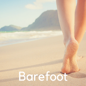 A woman walking barefoot on the beach