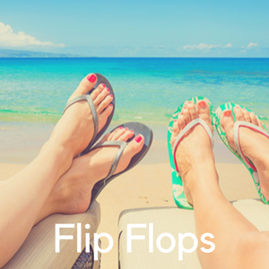 Two pairs of feet in flip flops on the beach