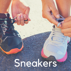 Two people tying their sneakers on the pavement