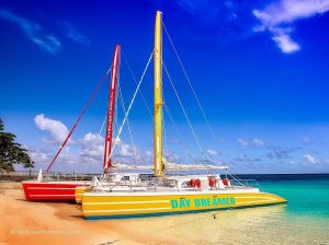 Two colorful sailboats are docked and waiting to take travellers on a Caribbean boat cruise