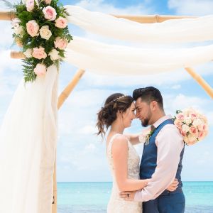 A couple embrace and celebrate their Jamaican wedding on the beach