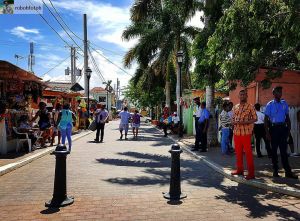 Pedestrians stroll down a cobblestone street while doing their Montego Bay shopping 